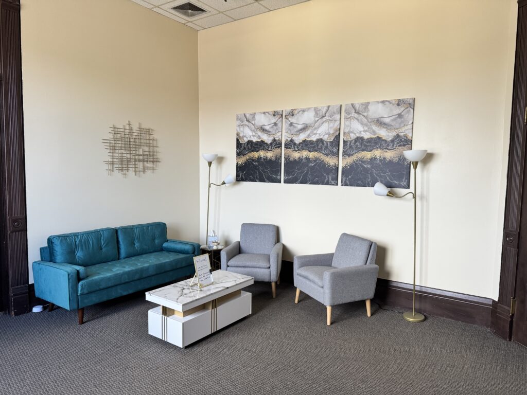 Cozy Teal Couch, Welcoming Space with Marble Table, and Marble and Gold wall art in the Waiting Room for Counseling Center